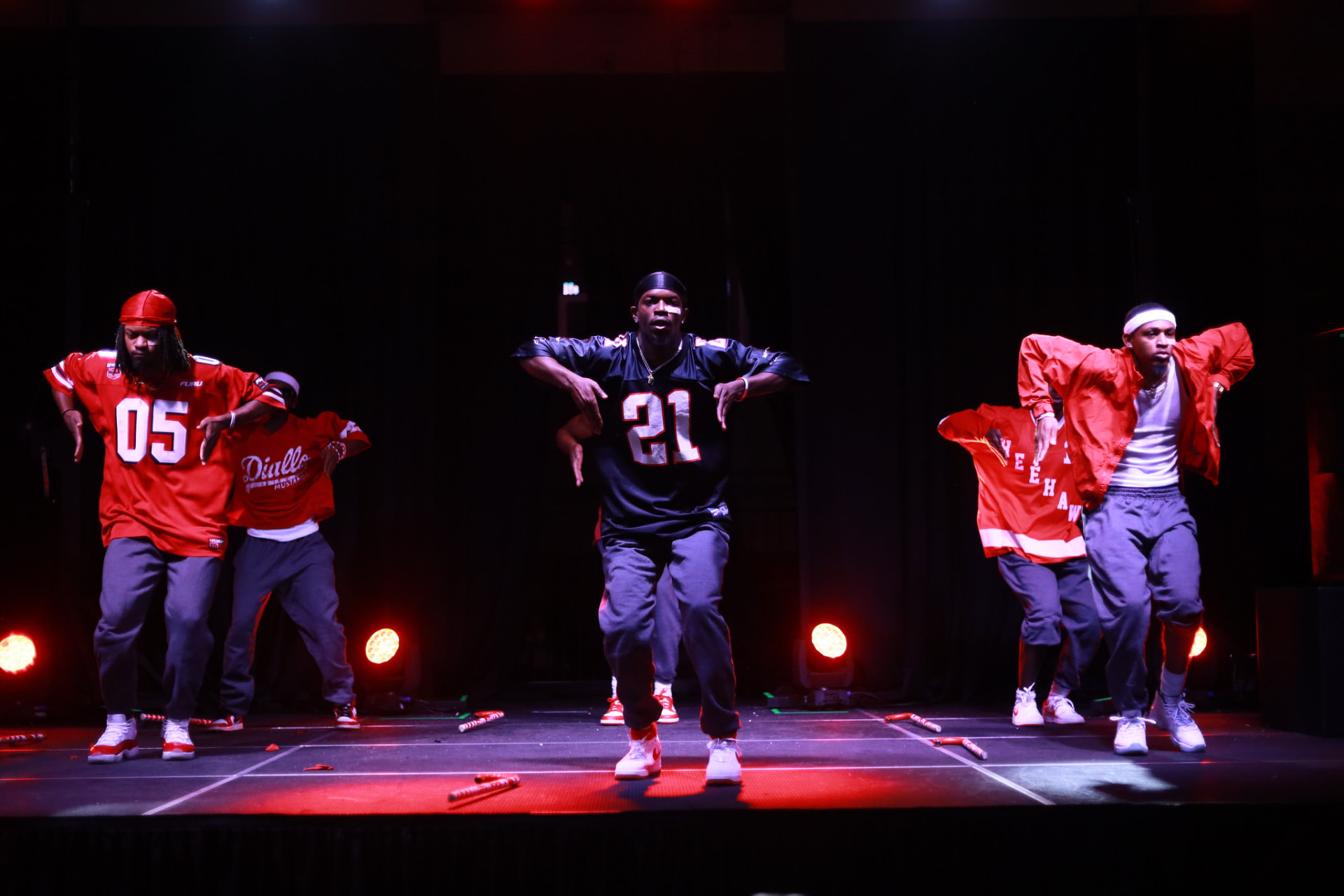 Step show performers on a red-lit stage